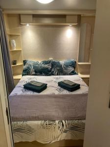 Bett in einem kleinen Zimmer mit zwei Kissen darauf in der Unterkunft Mobile home Oliveto in Poreč