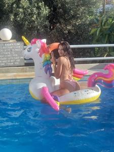 una mujer montando en una balsa de unicornio en una piscina en Villa Rena, en Batsi