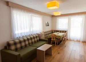 ein Wohnzimmer mit einem Sofa und einem Tisch in der Unterkunft Residence Armonia in Kolfuschg