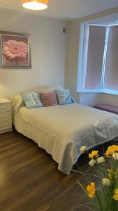 a bedroom with a bed with a window and flowers at Bexhill Stunning 2 bedroom Sea Front Bungalow in Bexhill