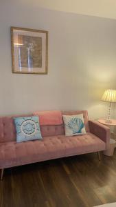 a brown couch in a living room with two pillows at Bexhill Stunning 2 bedroom Sea Front Bungalow in Bexhill