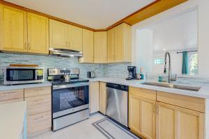 una cocina con armarios de madera y electrodomésticos de acero inoxidable en The Columbia City Hideaway, en Seattle