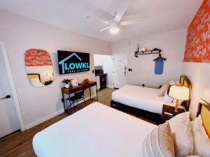 マイアミビーチにあるGreenview Hotel By Lowklのベッド2台とデスクが備わるホテルルームです。