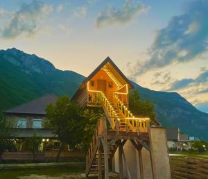 ein Baumhaus mit einer Treppe vor einem Haus in der Unterkunft TREEHOUSE The blue eye Vusanje in Vusanje