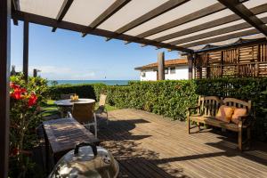 a patio with a bench and a table with a view of the ocean at Casa com Vista Mar e 2 Suítes | CBR 07 in Búzios