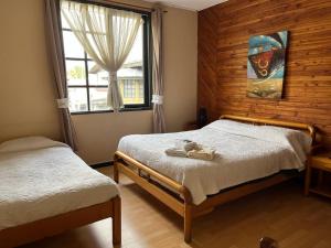 1 dormitorio con 2 camas y ventana en Hotel Sueños del Volcan, en Villarrica