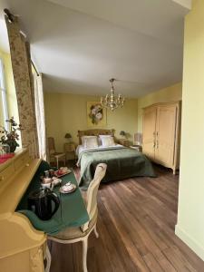 a bedroom with a green bed and a table at La Demeure d'Agapanthe in Vinay
