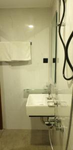 een badkamer met een witte wastafel en een spiegel bij Kandy City Inn in Kandy