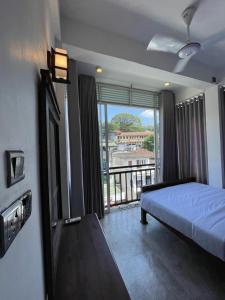 a bedroom with a bed and a balcony with a view at Kandy City Inn in Kandy