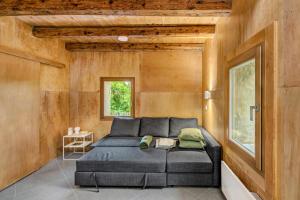 ein Schlafzimmer mit einem Bett in einem Zimmer mit Holzwänden in der Unterkunft Kőház a Hegyen in Badacsonytomaj