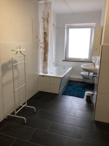 La salle de bains est pourvue d'une baignoire, de toilettes et d'une fenêtre. dans l'établissement Monteurwohnung in Merseburg, à Merseburg