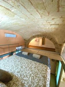 Ce lit se trouve dans un dortoir doté d'un mur en pierre. dans l'établissement The Nest of Envy, à Bari