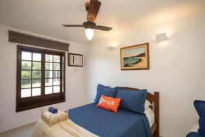 a bedroom with a bed and a ceiling fan at Casa com Vista Mar e 2 Suítes | CBR 07 in Búzios