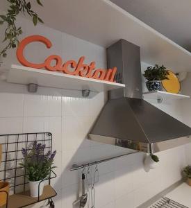 una cucina con cappa di metallo sopra un piano cottura di Coqueto apartamento a dos minutos de la playa a Somo