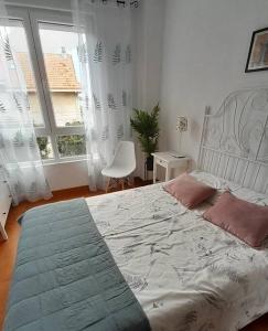 una camera con letto, sedia e finestre di Coqueto apartamento a dos minutos de la playa a Somo