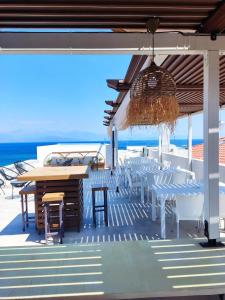 a patio with tables and chairs and the ocean at ThalaSEA Apartments in Chrani