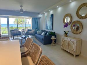 sala de estar con sofá azul y sillas en Beachfront Villa in the Rio Mar Resort, en Río Grande