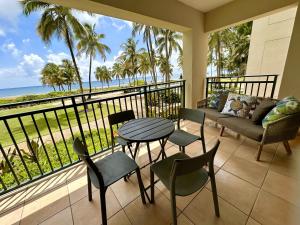 einen Balkon mit einem Tisch, Stühlen und Meerblick in der Unterkunft Beachfront Villa in the Rio Mar Resort in Rio Grande