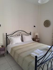 um quarto com uma cama grande e almofadas brancas em Penny's Beach Cottage em Galaxidi