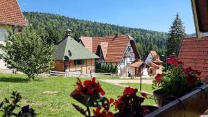 Blick auf ein kleines Dorf mit einer Kirche in der Unterkunft Planinska Kuća Dušan in Mitrovac
