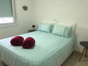 una camera da letto con un letto con due cuscini rossi sopra di Buenos Aires 705 a Osório