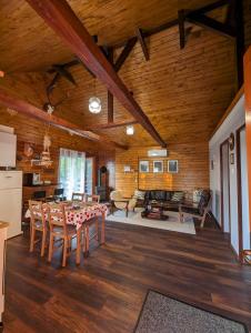 a dining room and living room with a table and chairs at Cabana Nyiko cu ciubăr in Lupeni