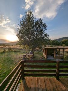a wooden deck with a table and a tree at Cabana Nyiko cu ciubăr in Lupeni +62 photos