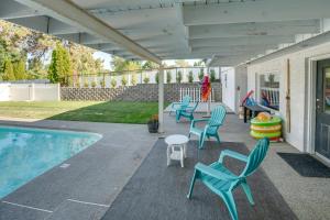 a patio with chairs and a swimming pool at Epic Family Getaway with Pool, Game Room and Fire Pit! in East Wenatchee