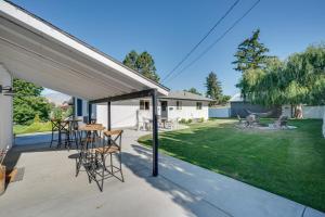 a patio with tables and chairs and a yard at Epic Family Getaway with Pool, Game Room and Fire Pit! in East Wenatchee