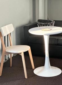 a white table and a chair next to a couch at HOSTEL/HOTELL 3A in Maardu