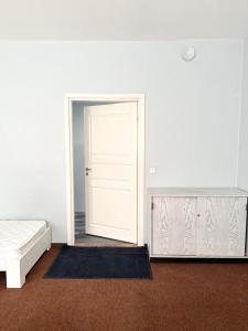 マールドゥにあるHOSTEL/HOTELL 3Aの白いドアと鏡付きのベッドルーム