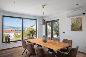 - une salle à manger avec une table et des chaises en bois dans l'établissement House & Home Slatine, à Slatine