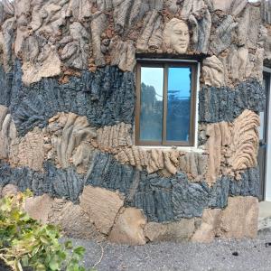 - une fenêtre dans un mur en pierre avec une statue dans l'établissement Pensao Zé Doce, à Portela