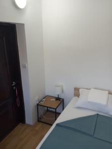 1 dormitorio con 1 cama y 1 mesa con lámpara en Airport MD rooms en Belgrado