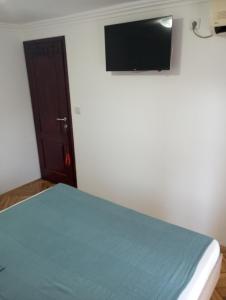 um quarto com uma cama e uma televisão de ecrã plano na parede em Airport MD rooms em Belgrado