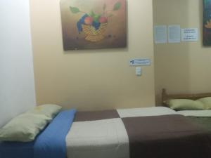 ein Schlafzimmer mit einem Bett und einem Gemälde einer Ananas in der Unterkunft Hostal-de don Pablo Del Centro Comercial in Quito
