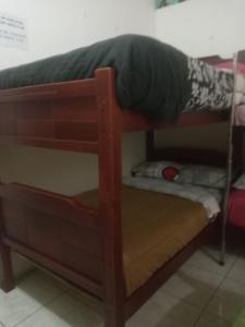 ein Etagenbett mit einer Person, die darauf liegt in der Unterkunft Hostal-de don Pablo Del Centro Comercial in Quito
