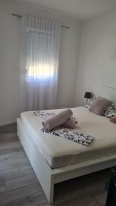 ein weißes Bett mit zwei Kissen darüber in der Unterkunft Apartment Merry - Free private Parking & Garage in Mostar