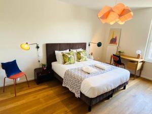 een slaapkamer met een bed en een bureau met een stoel bij Luxury 2 bedrooms in Limpertsberg - 61 in Luxemburg
