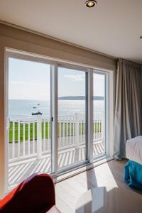 a room with a large window with a view of the ocean at Riotel Perce in Perce