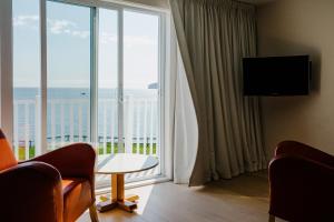 a room with a large window with a view of the ocean at Riotel Perce in Perce