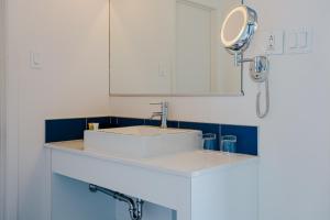 a bathroom with a white sink and a mirror at Riotel Perce in Perce