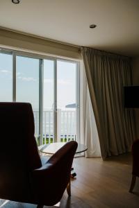 a living room with a chair and a large window at Riotel Perce in Perce