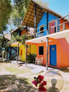 ein farbenfrohes Haus mit einer Glasschüssel davor in der Unterkunft Pousada Cajibá Imbassaí in Imbassai