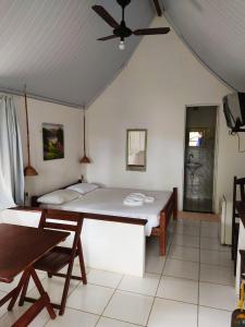 a bedroom with a bed and a ceiling fan at Pousada Cajibá Imbassaí in Imbassai