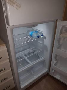 an empty refrigerator with a bottle of water in it at Lovely and cozy 2 bedroom apt with oceanic view in Roger