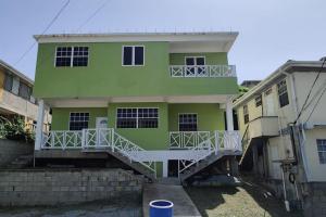 un edificio verde con una escalera delante en Lovely and cozy 2 bedroom apt with oceanic view, en Roger