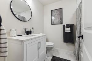 een witte badkamer met een wastafel en een spiegel bij Modern City living in Philadelphia