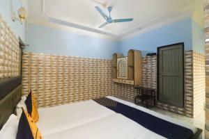 - une chambre avec un lit et un ventilateur de plafond dans l'établissement Flagship Hotel Maitry, à Cuttack