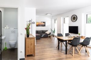 a living room and dining room with a table and chairs at Heilsteinlodge in Einruhr
